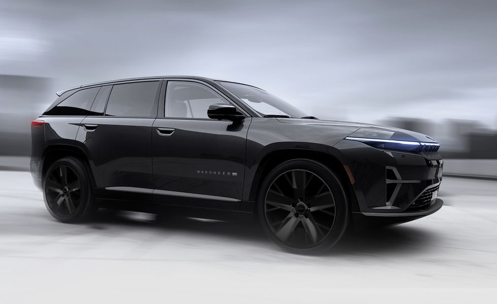 Black electric SUV in side view on a gray studio background