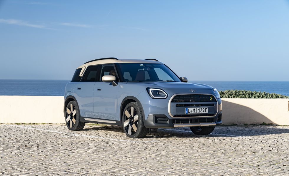Blue compact SUV parked by the sea on a sunny day