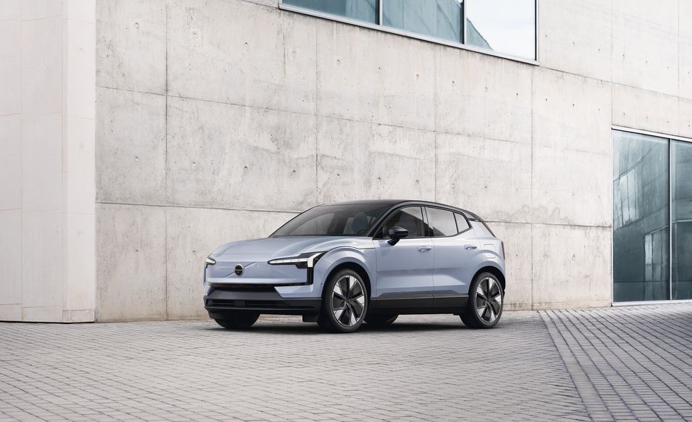 Silver SUV parked beside a concrete building in a modern outdoor plaza