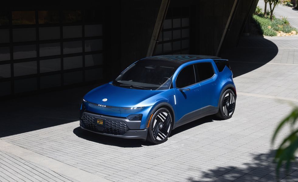 Blue compact SUV parked on a sunlit driveway beside a modern building