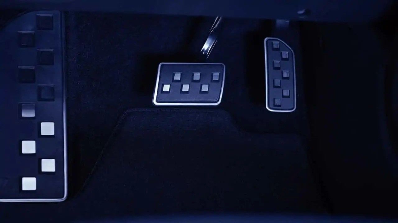 Three dark blue remote controls with white buttons on a dark surface