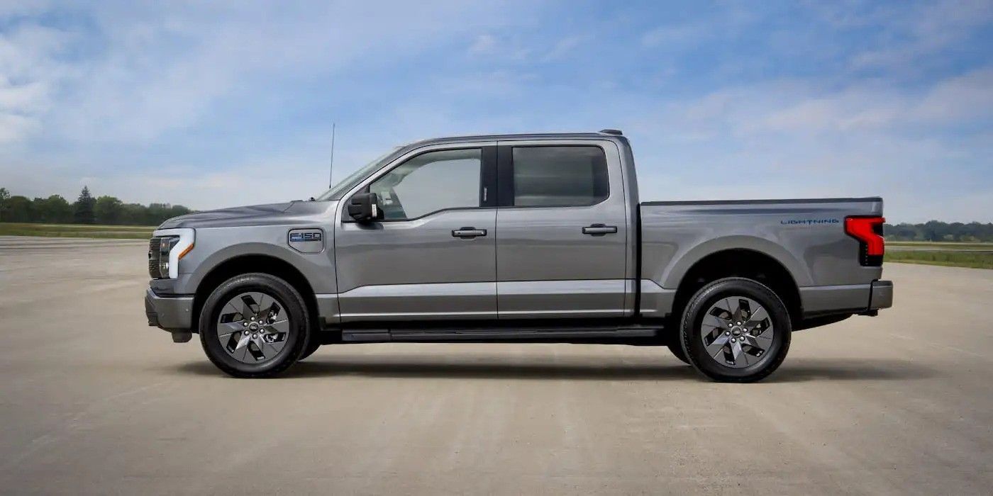 Silver crew cab pickup truck in side view on a paved lot