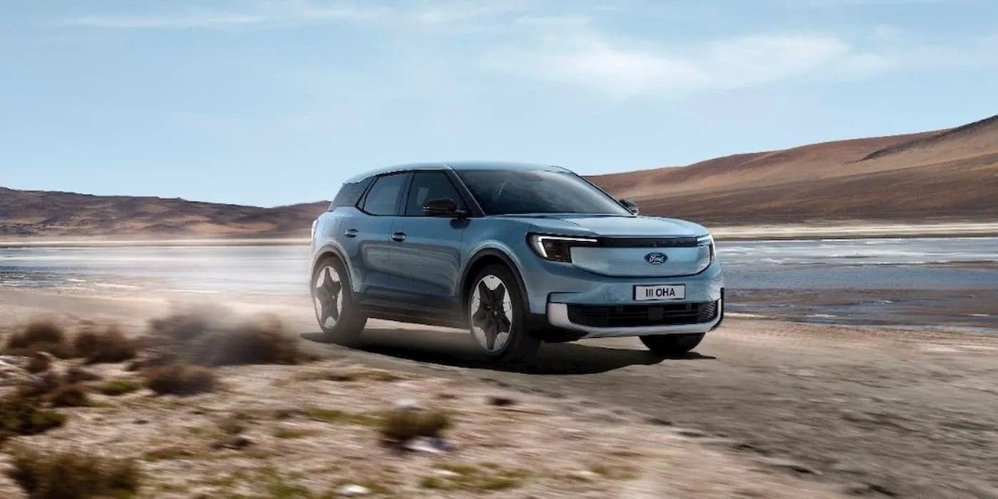 Blue SUV driving on a dusty road in a desert landscape