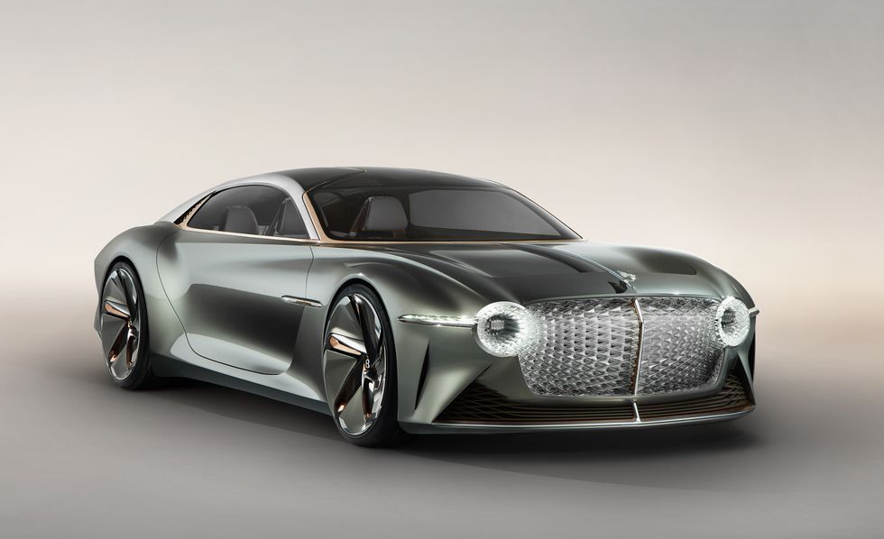 Sleek silver concept sports car on a studio background, front-left view with large grille and round headlights