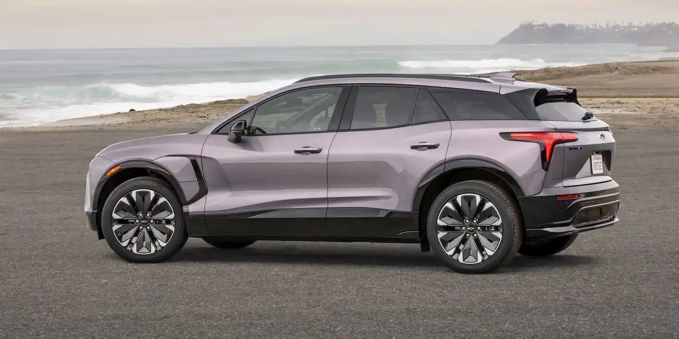 Gray SUV parked on a coastal road with ocean waves in the background