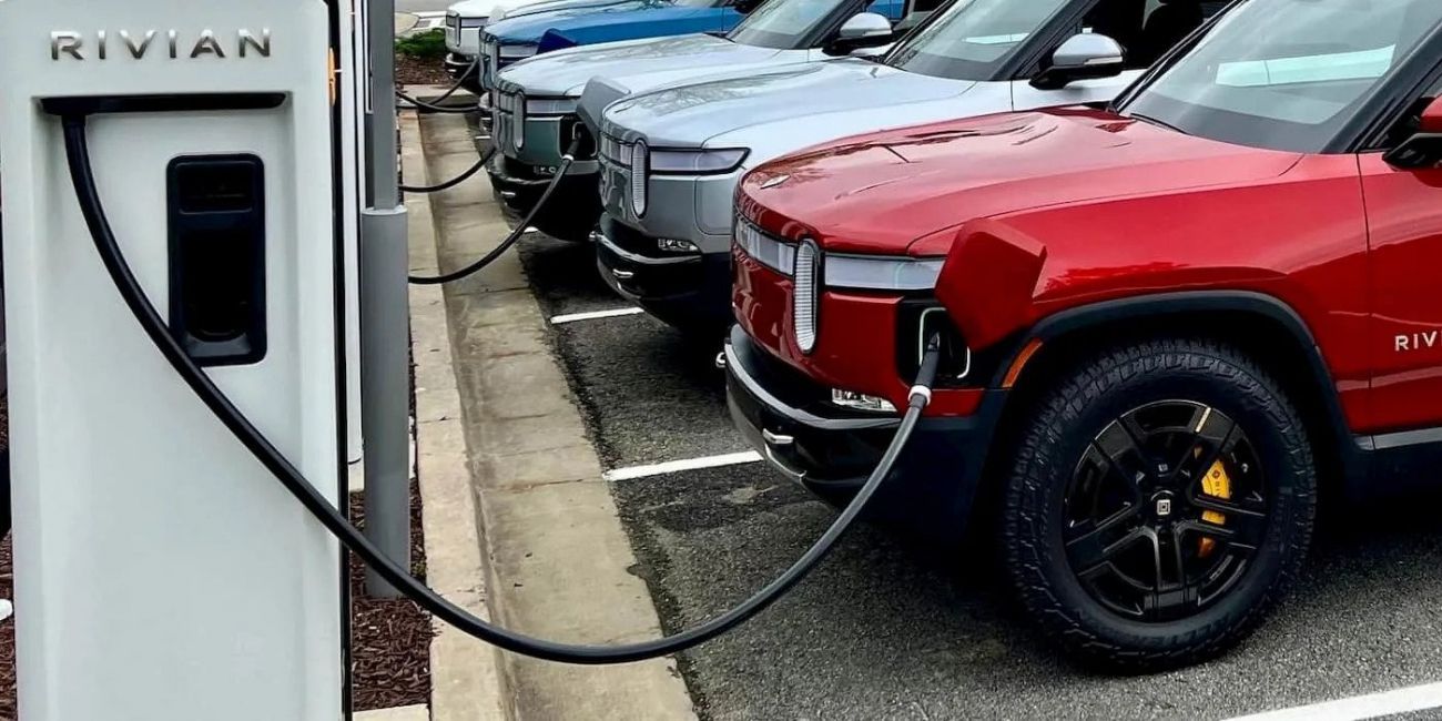 Rivian charging station with electric vehicles parked in a row, including a red truck