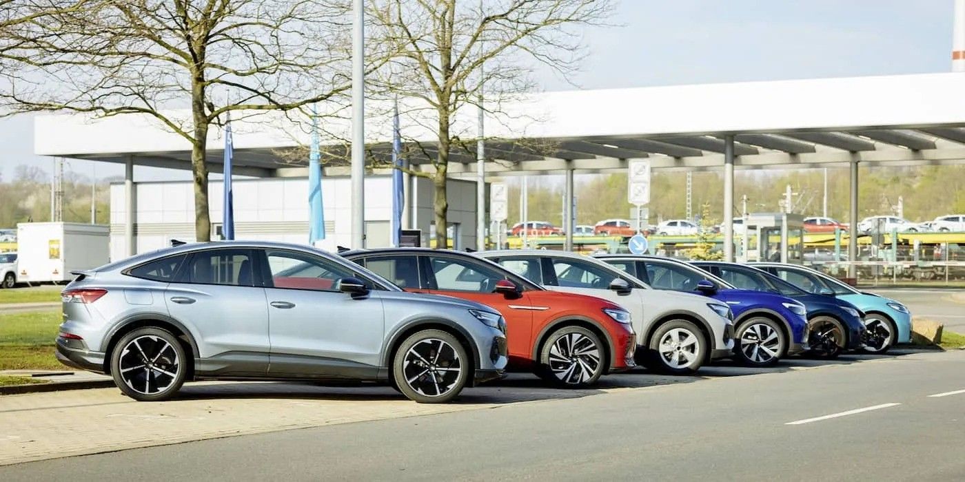 Row of parked electric cars in silver, orange, blue, and black outside a modern building