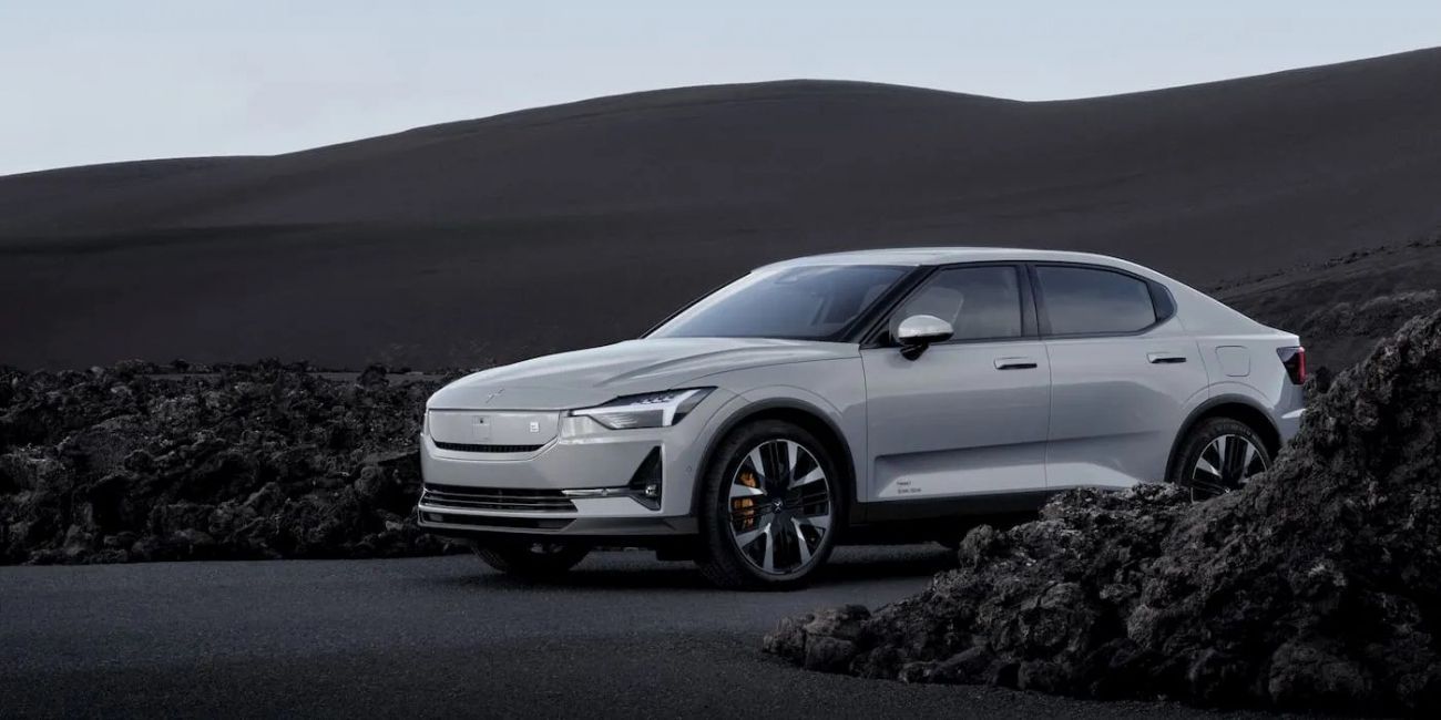 Silver sedan on a dark rocky landscape at dusk