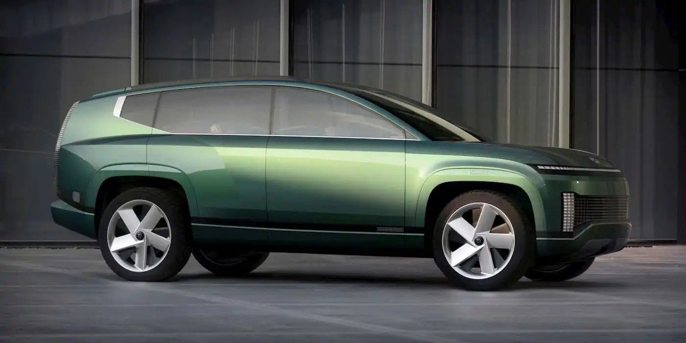 Green futuristic concept SUV in side view on a dark studio backdrop