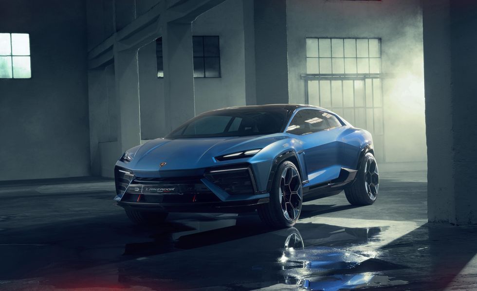Blue sports car parked in a dim industrial garage with wet floor reflections