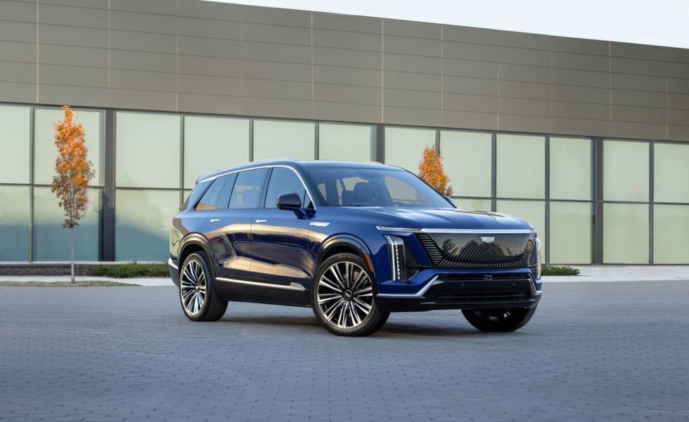 Blue SUV parked in front of a modern glass building