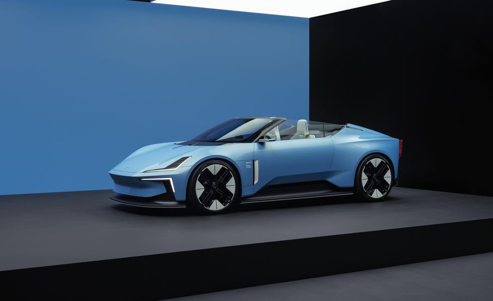 Light blue convertible sports car on a dark platform against blue and black walls