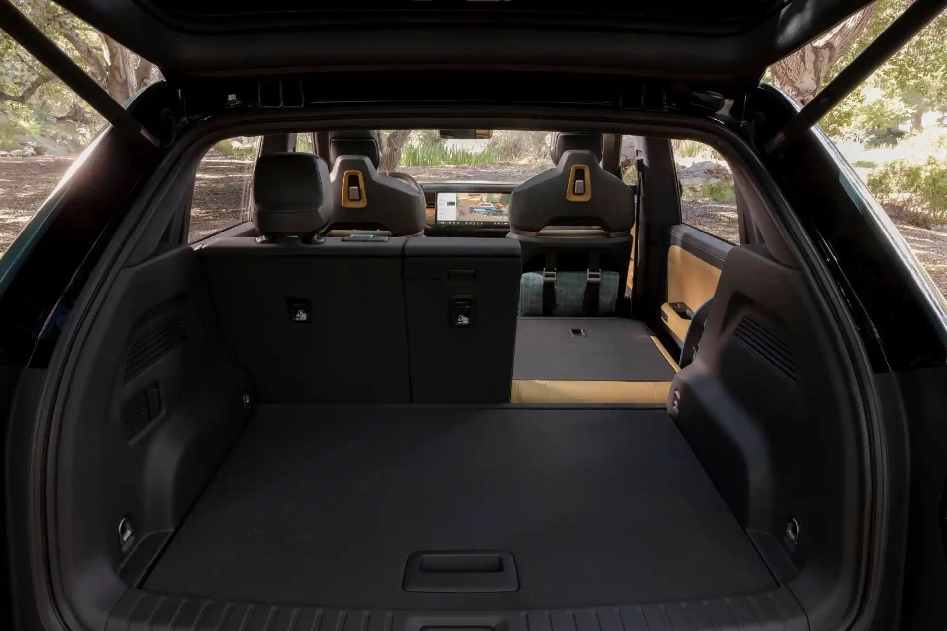 Open SUV cargo area with folded rear seats and black interior, viewed from the back.
