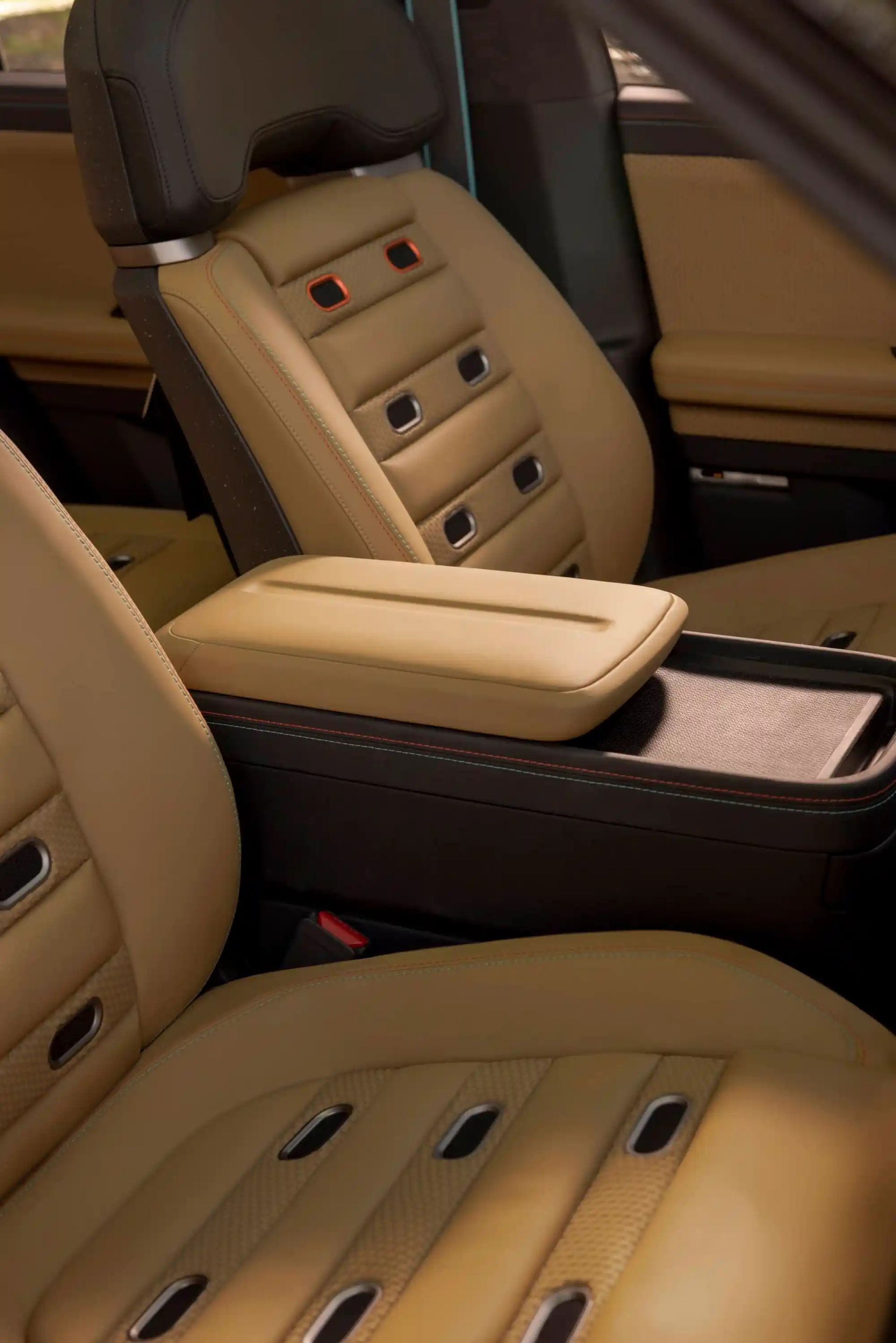 Beige leather car interior with quilted seats, center armrest, and dark wood trim