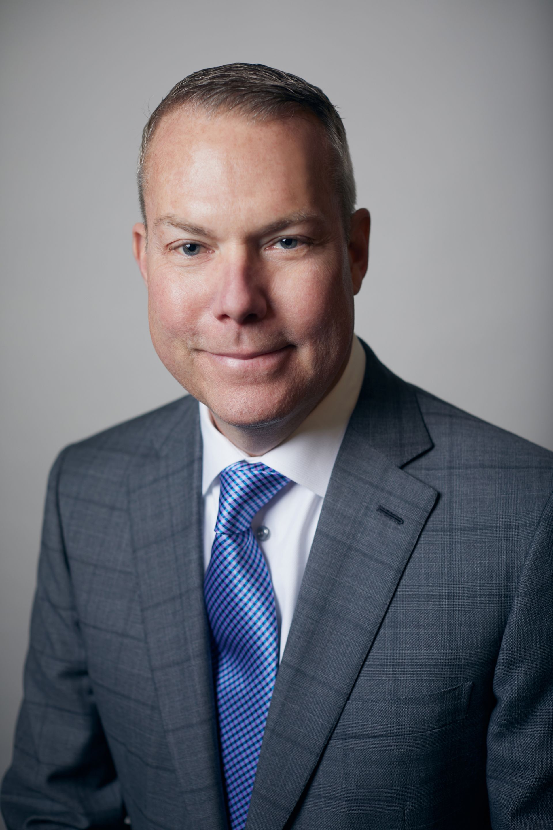 A man in a suit and tie is standing in front of a building.