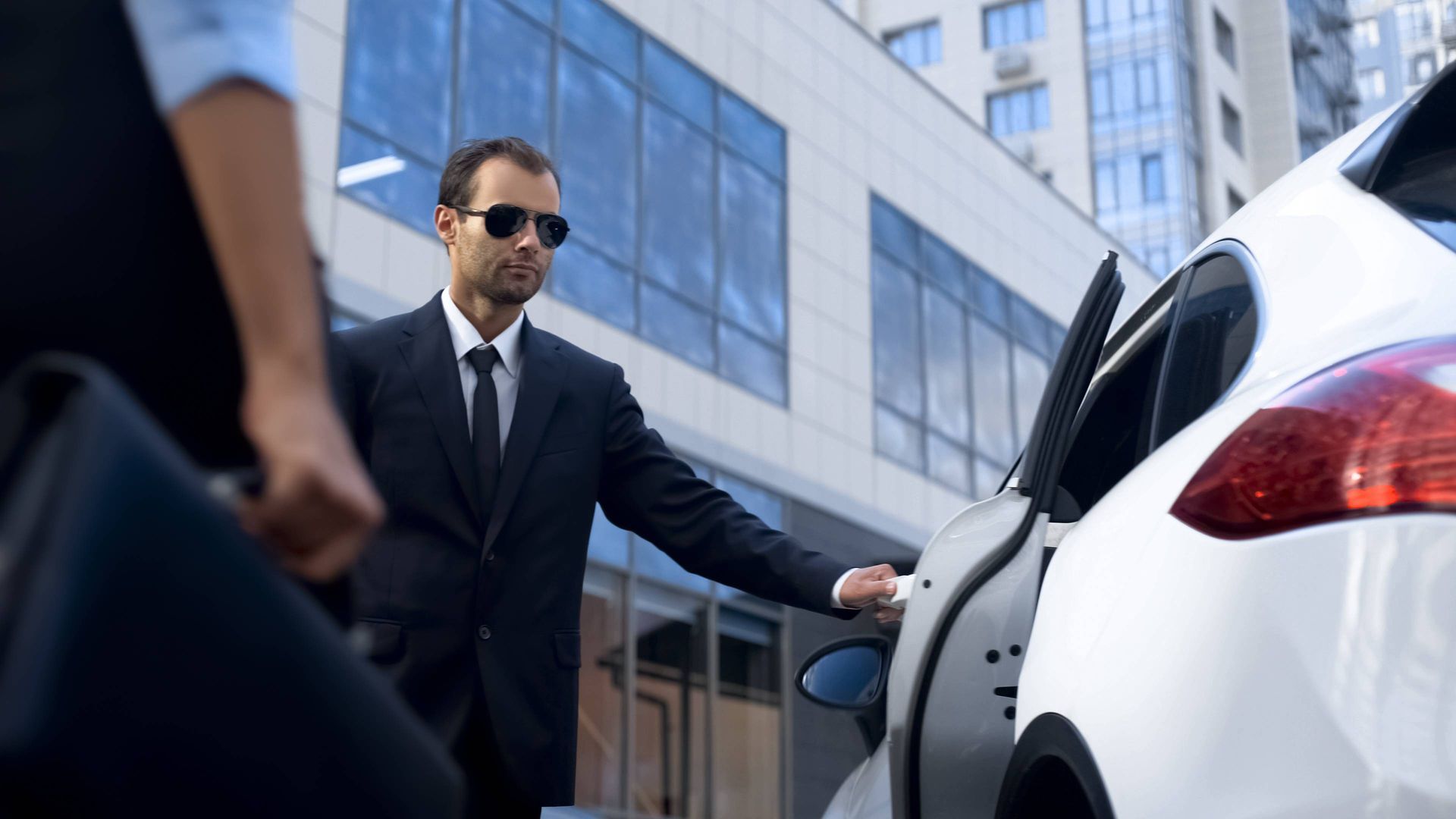 Executive in a grey suit speaking to colleagues