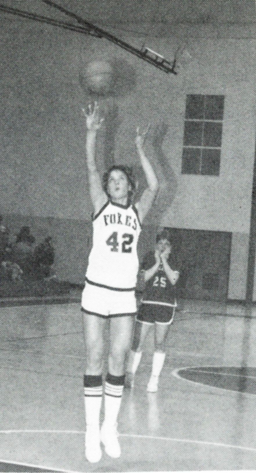Female basketball student shooting a basket during a game