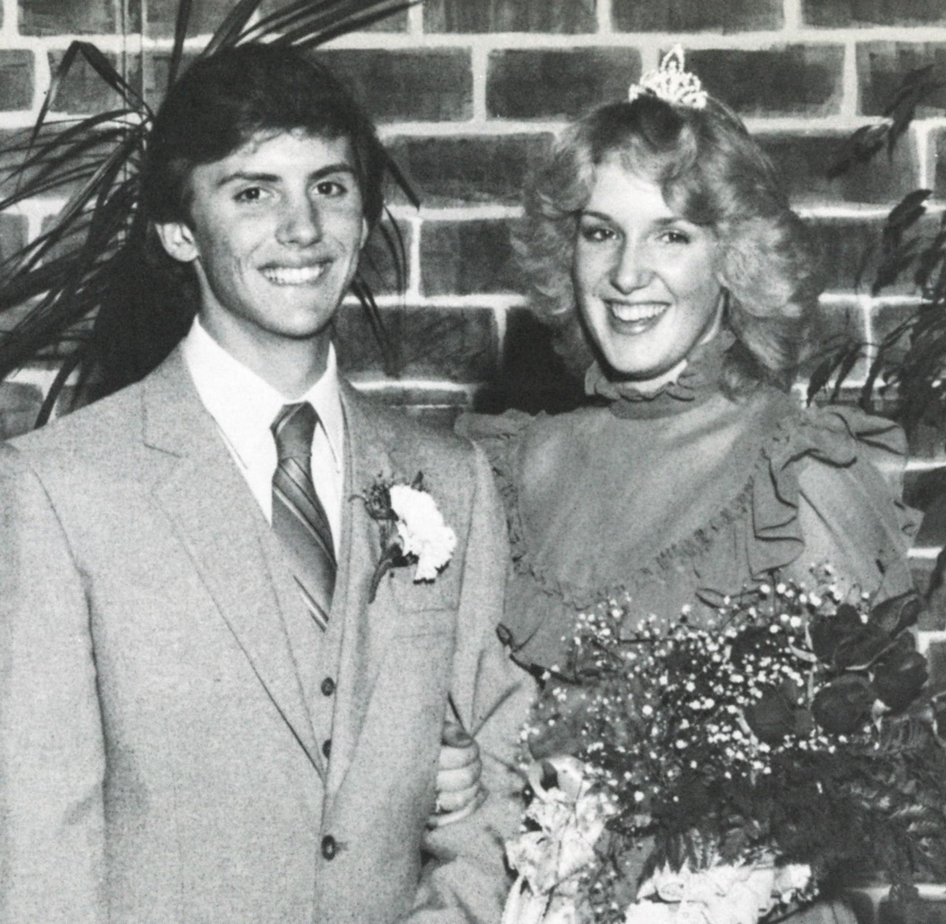 Male and female in formal dress - she is wearing a crown and holding flowers
