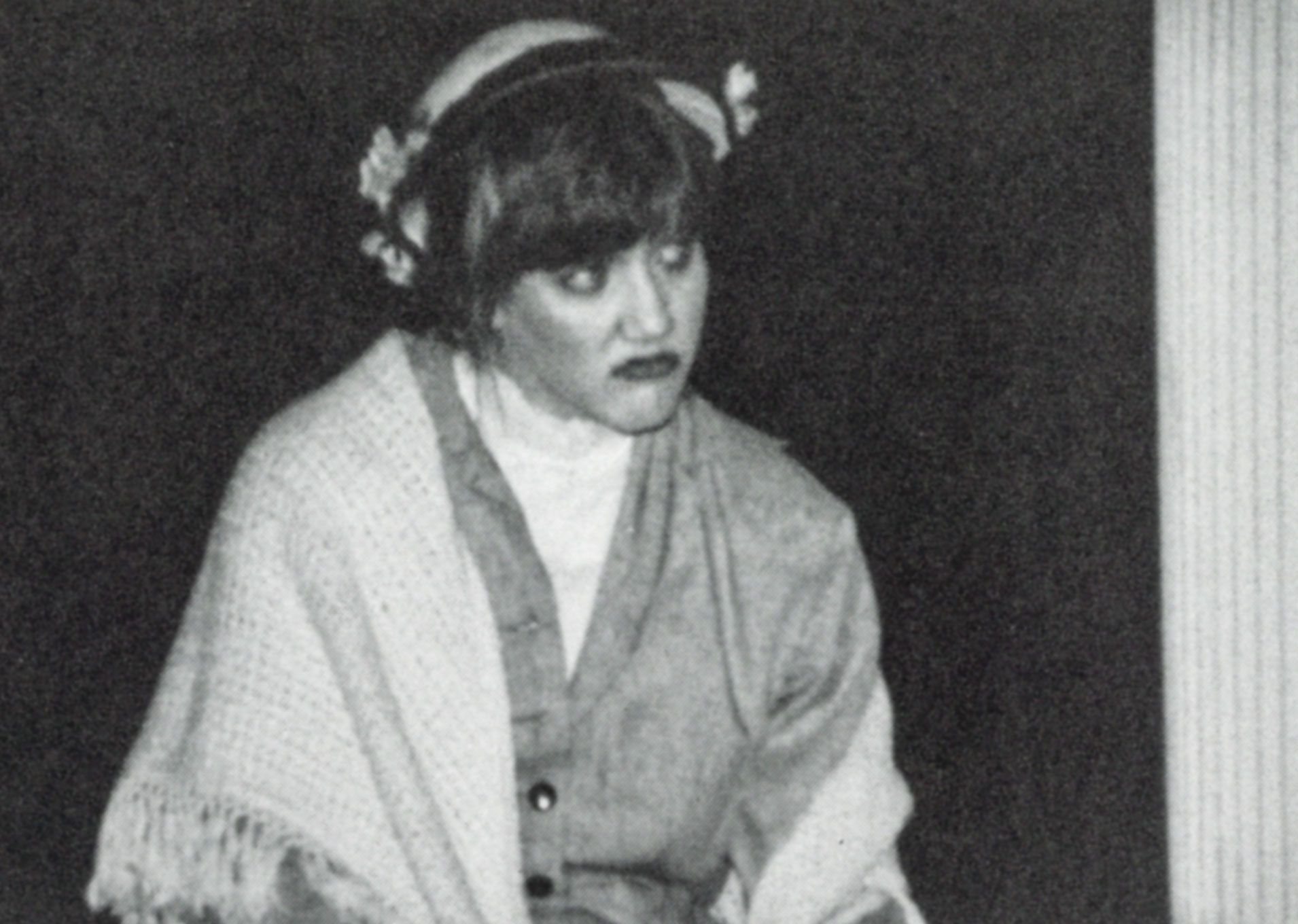 Disgruntled female sitting by a pillar