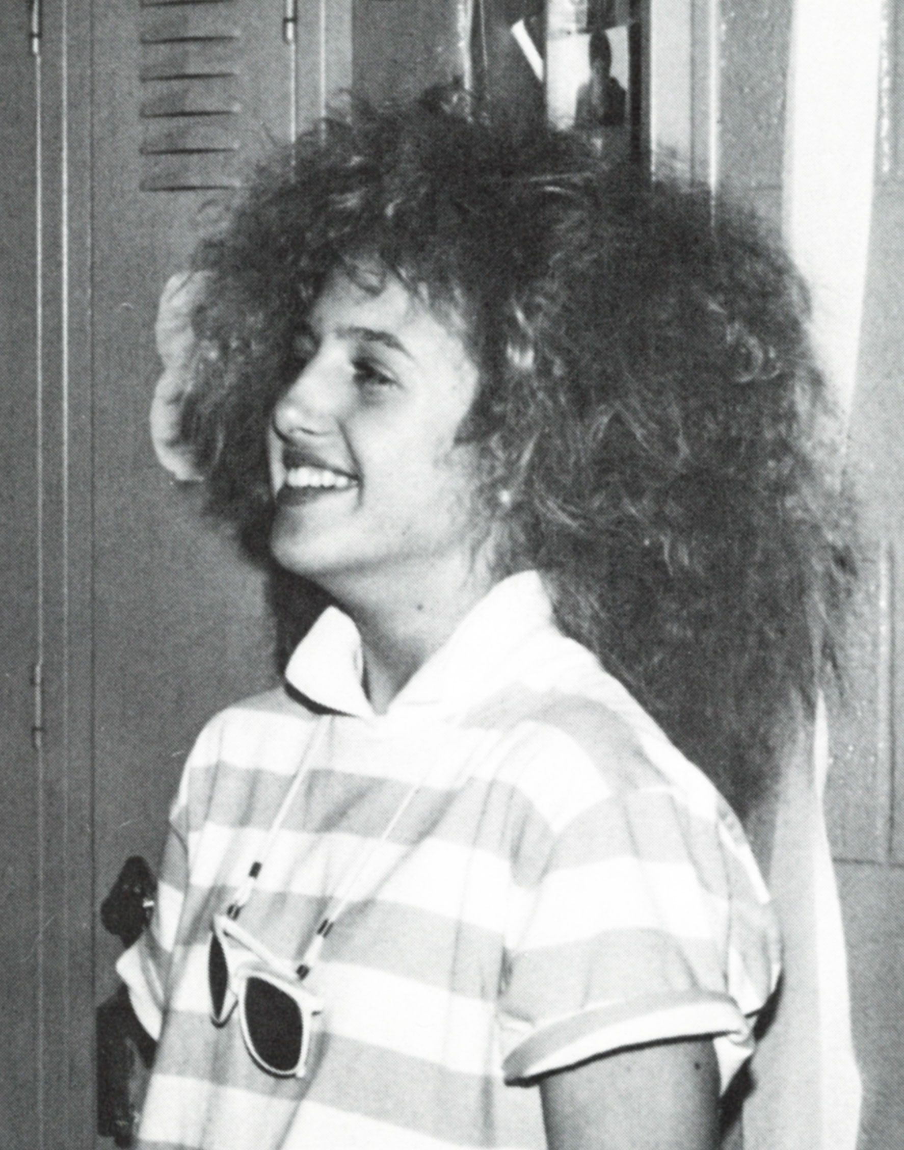 Smiling girl looking to the left with iconic 1980s hair