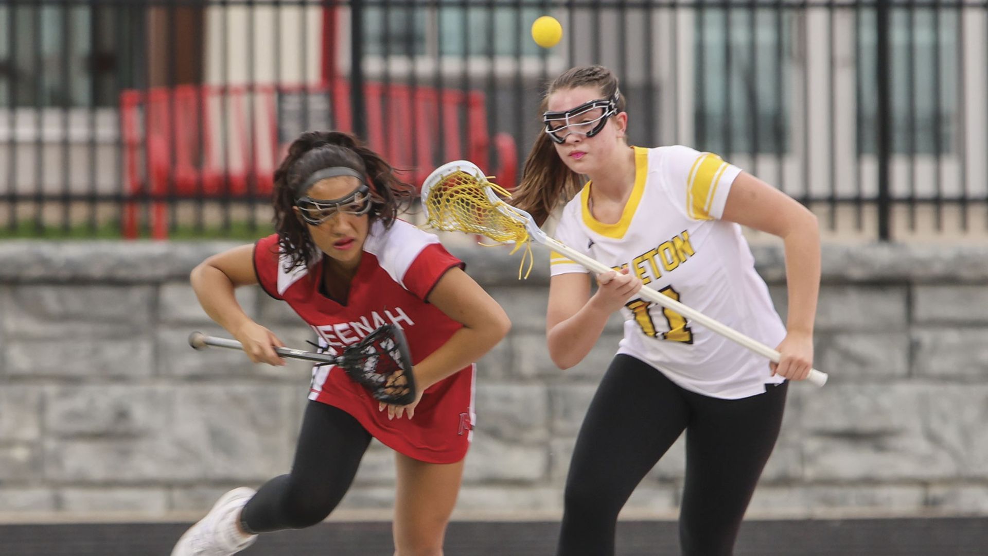Female lacrosse player going after the ball