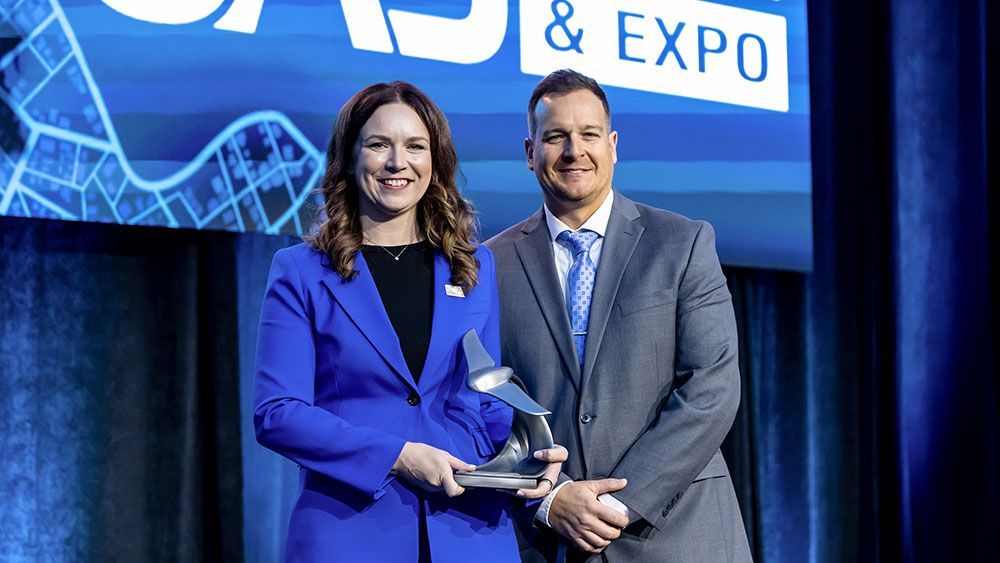 Erin Roesler on stage with an award