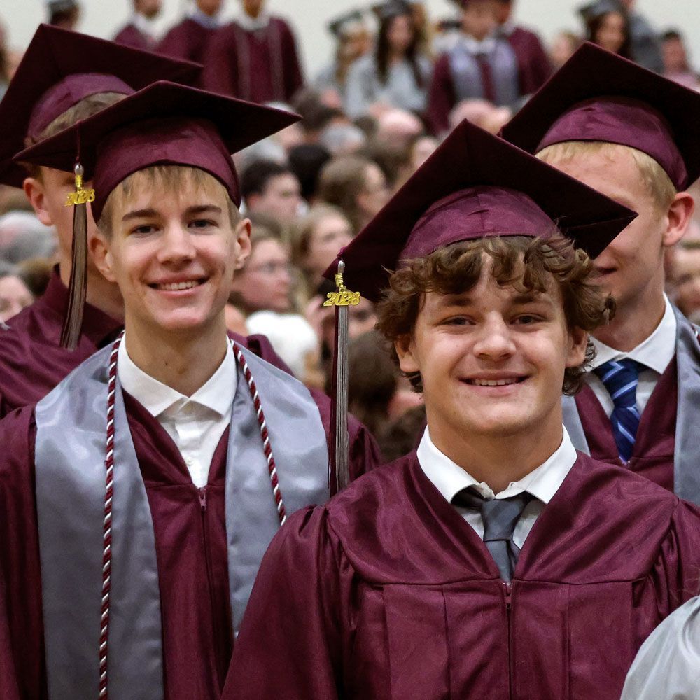 Two male students walking down the aisle during processional