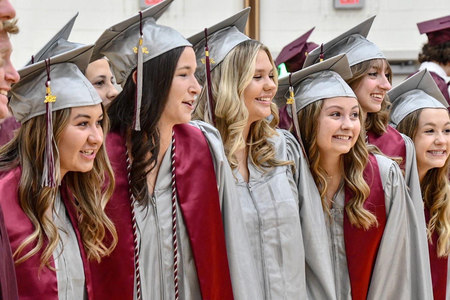 Side view of a group of 6 girls, smiling at someone else's camera