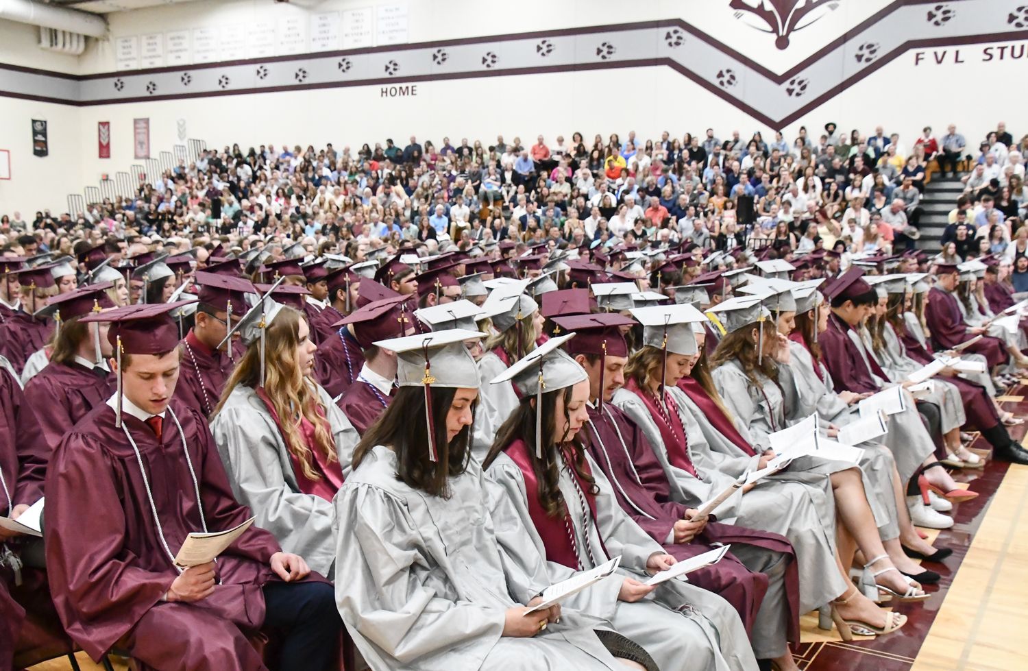 Students in their seats and bleachers filled with friends and family of the graduates