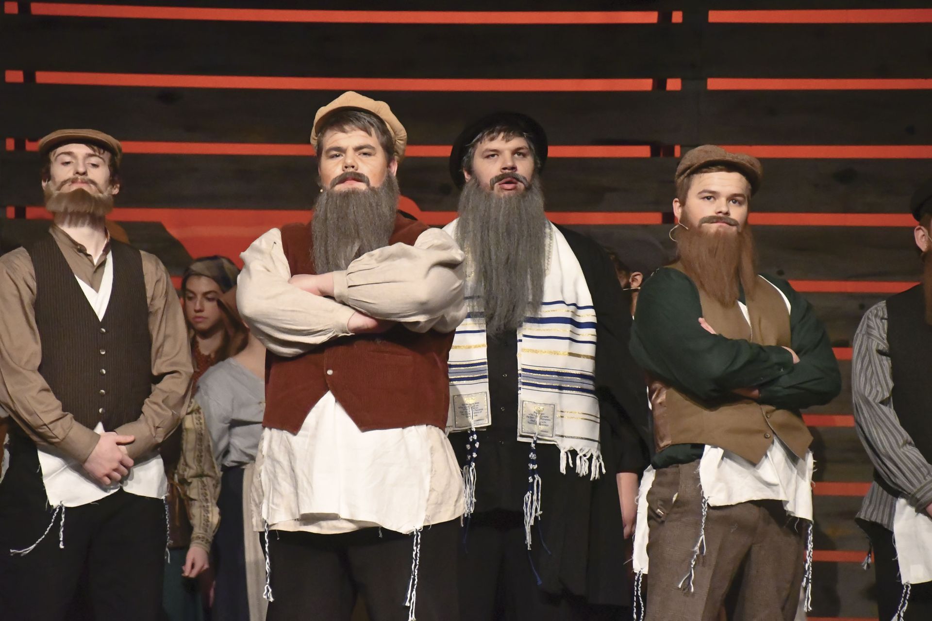 Several male students performing in Fiddler on the Roof