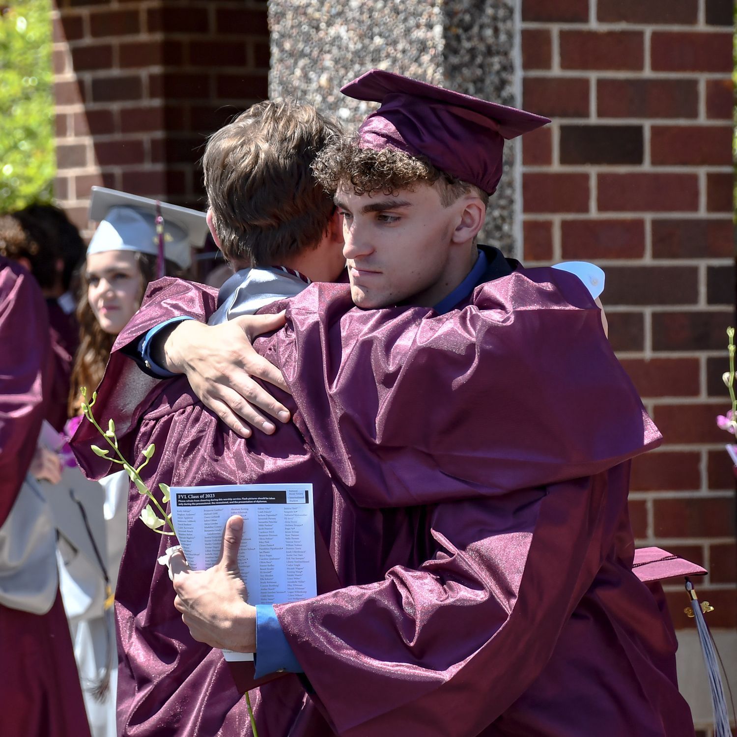 Two guys hugging, outside, after the ceremony