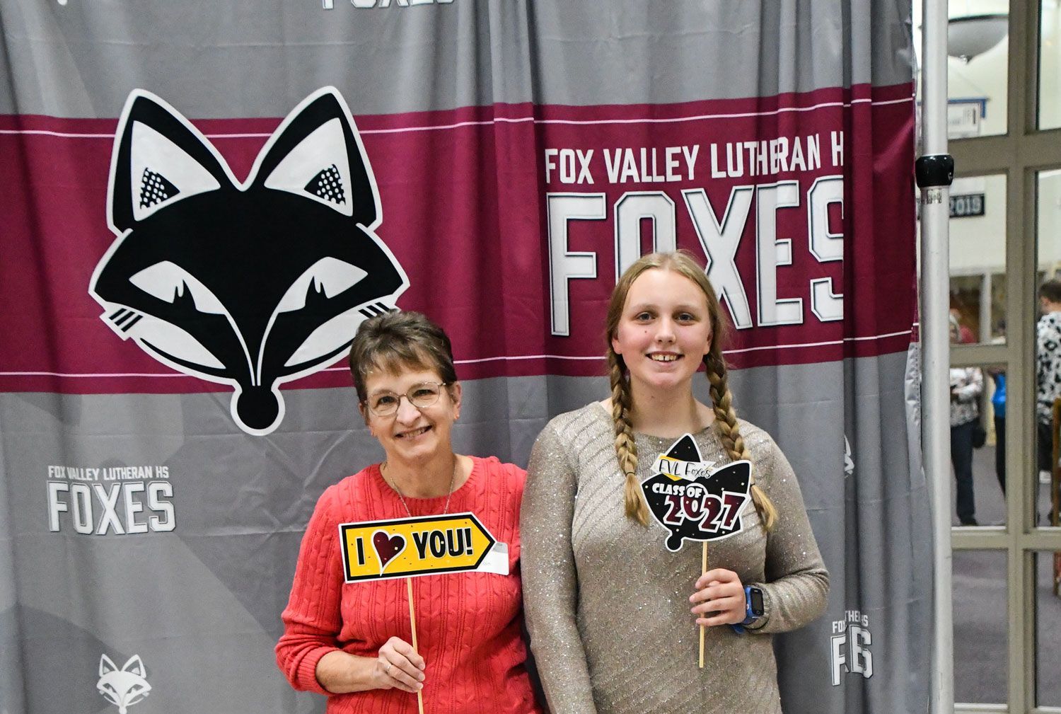 Grandma and granddaughter standing in front of the FVL photo-op backdrop