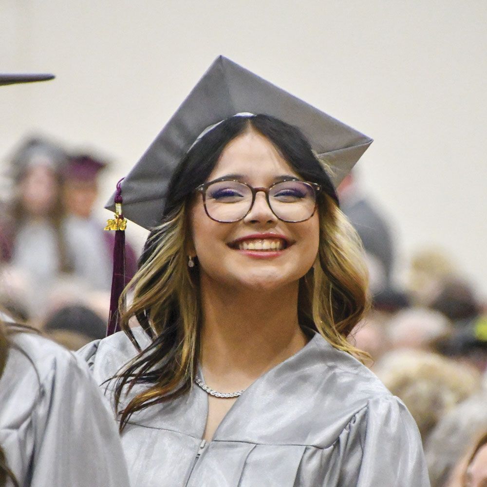 One smiling female graduate, looking at the camera