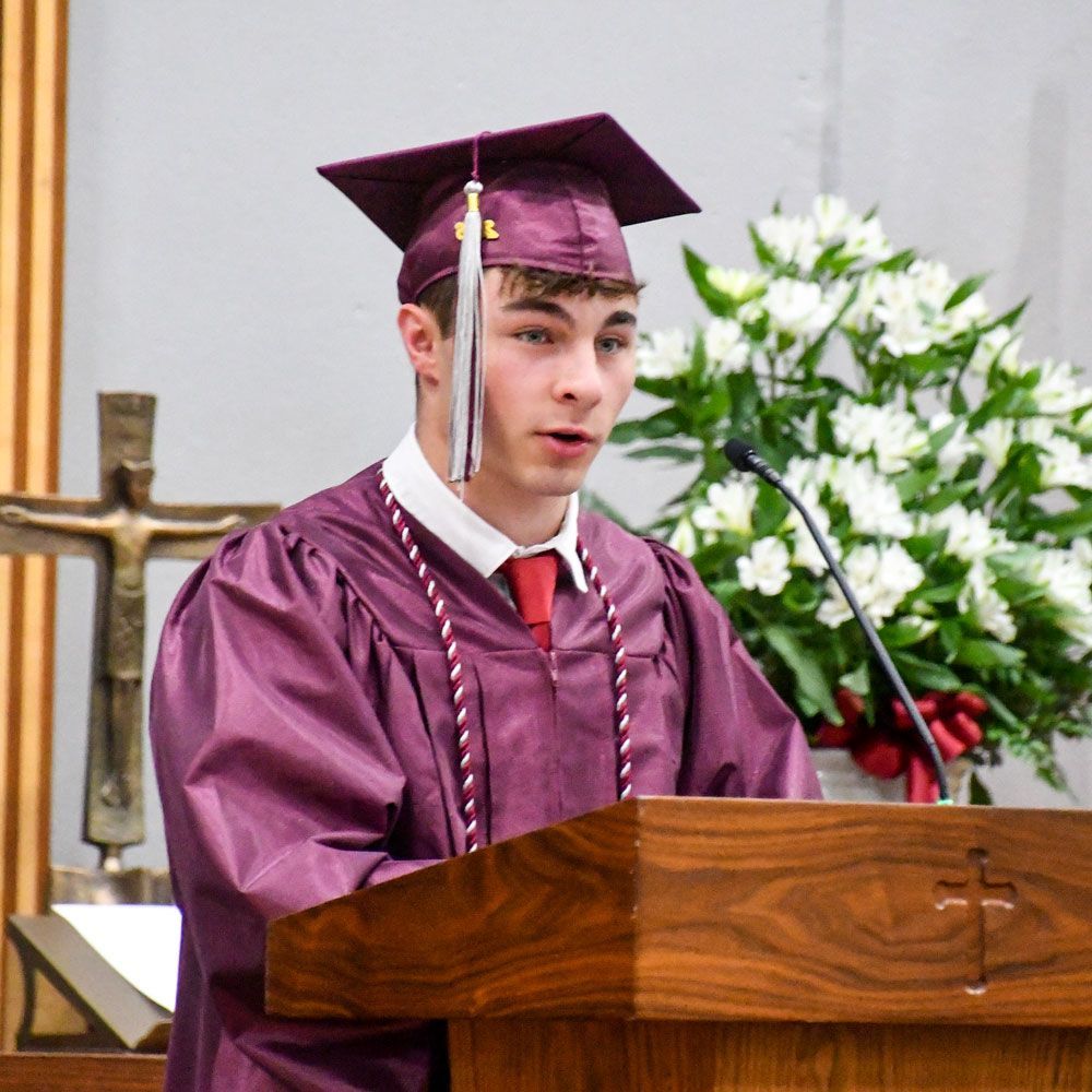 Gabriel Heiges in cap and gown, giving his speech at graduation