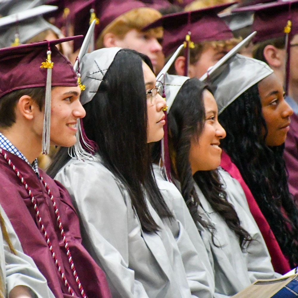 Several students in their chairs, looking at the stage and smiling