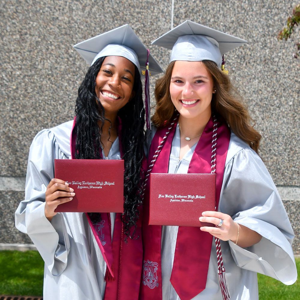 Two happy female grads, outside, after ceremony