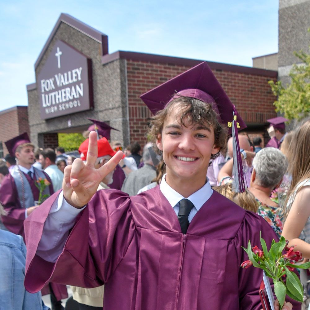 Male student smiling at the camera with entrance to FVL behind him