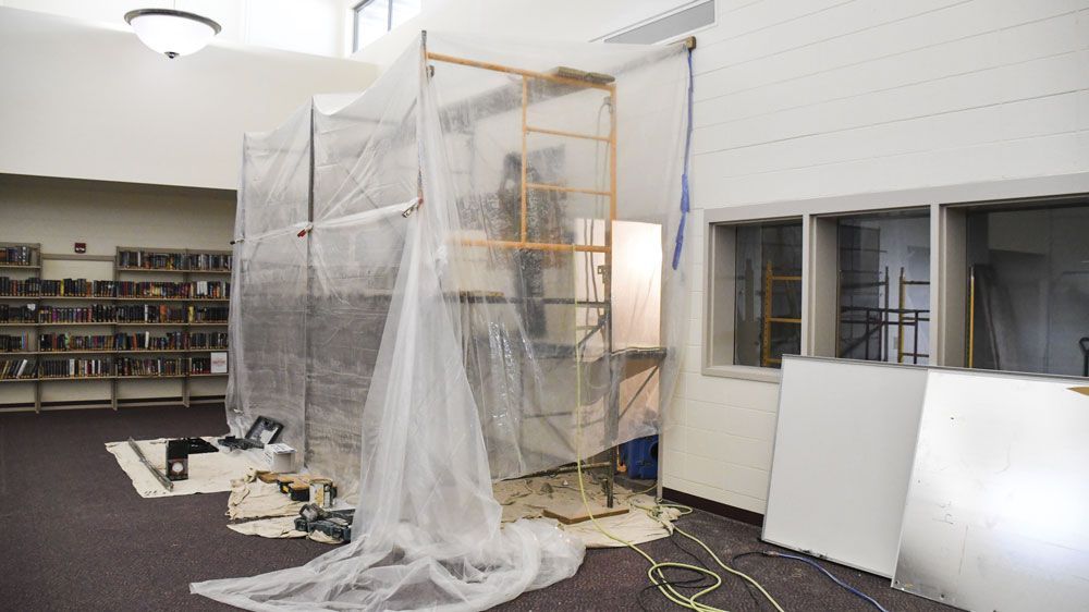 Media Center with scaffolding and a plastic tarp