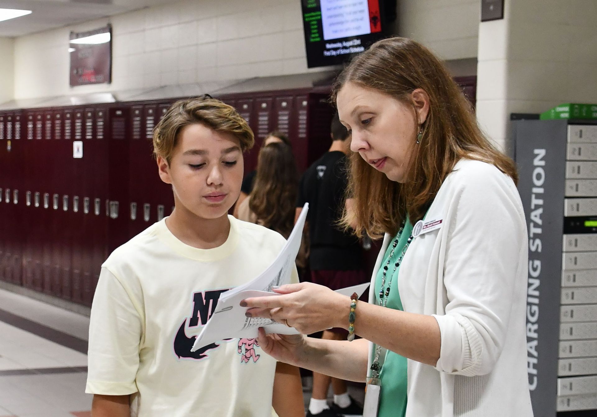 Aleah Friemark helping a student in the FVL hallways