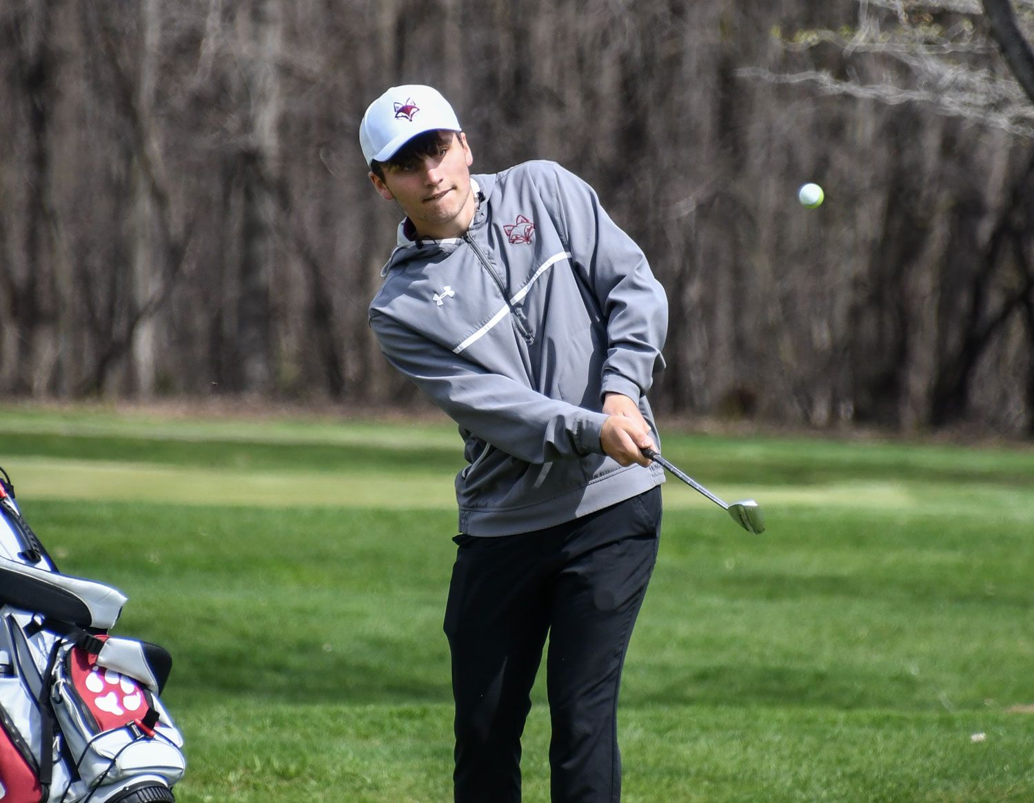 Male golf team member, taking a swing