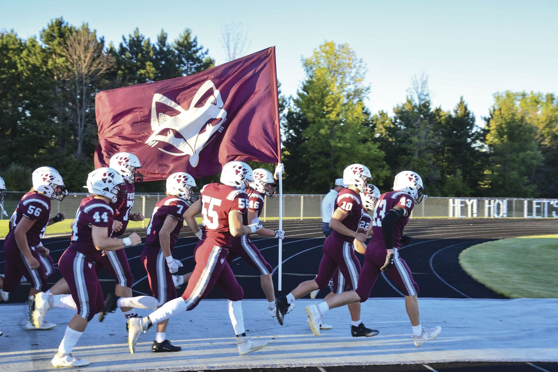Team members carrying the foxhead flag as they enter the stadium
