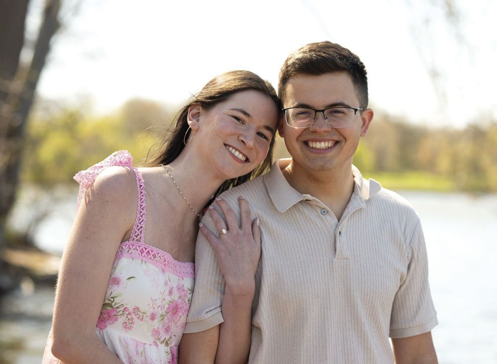 Smiling Carolina and Ben together outdoors, next to the water