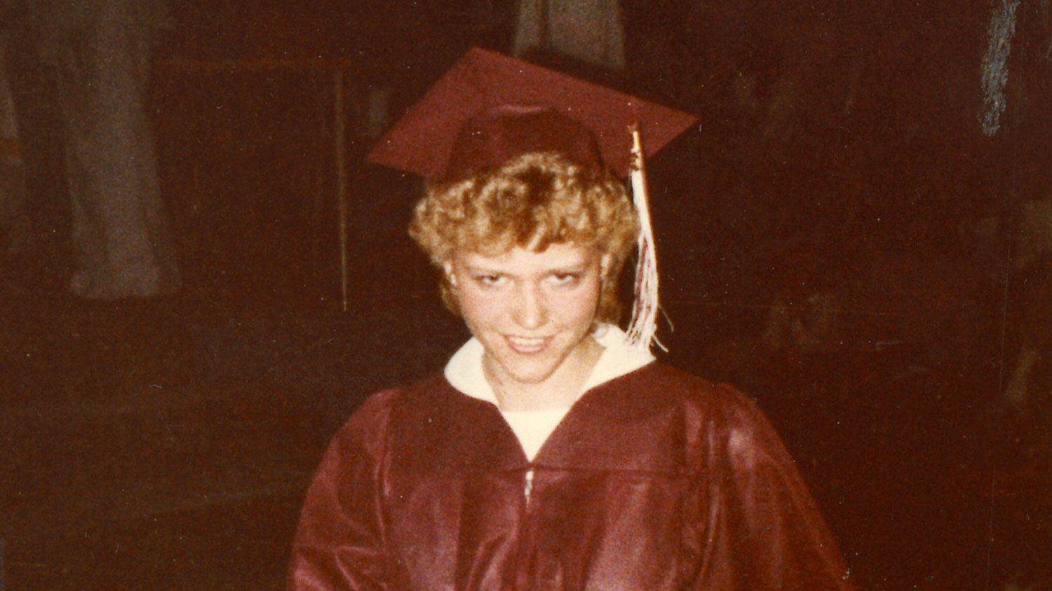 Smiling Krista in graduation cap and gown