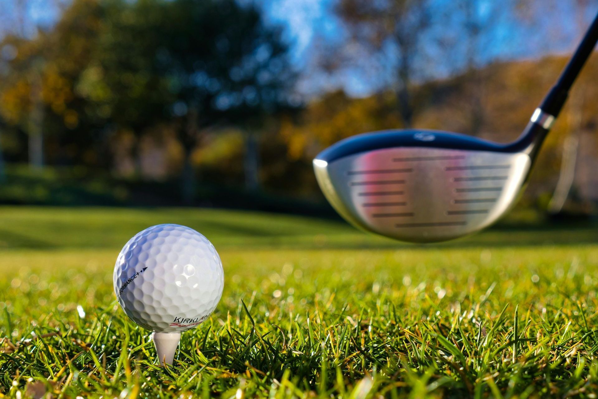 Golf club ready to hit ball on tee