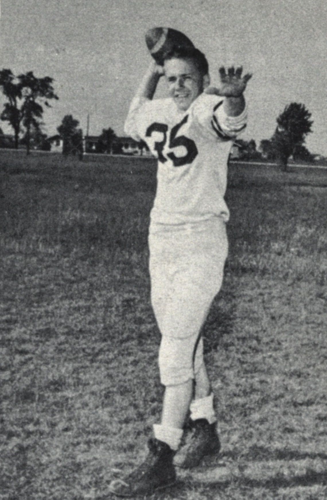 Football player posing with football for yearbook - as if throwing the ball