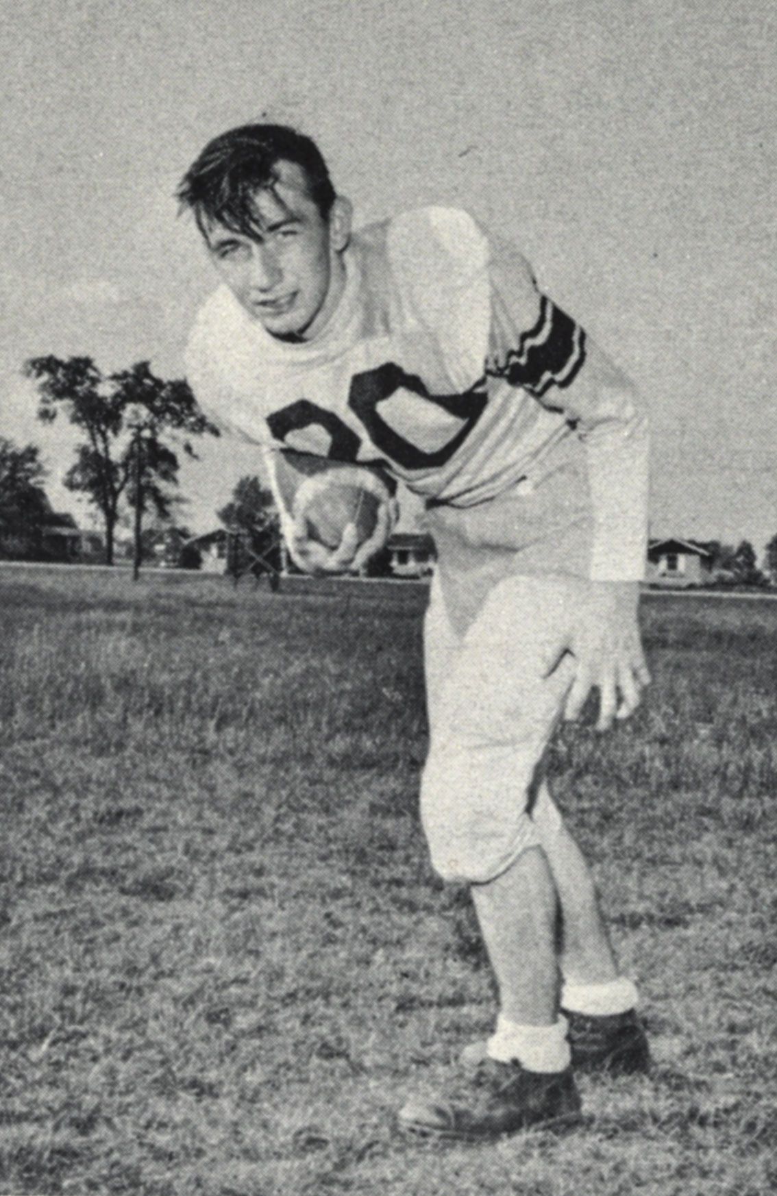 Football player posing with football for yearbook