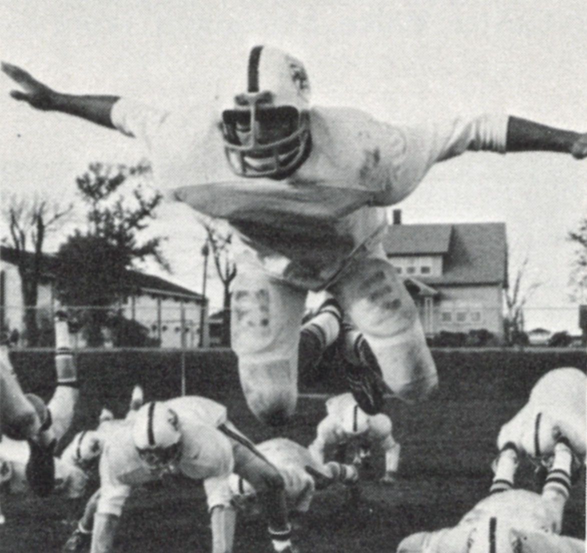 Football player with arms outstretched, in the air