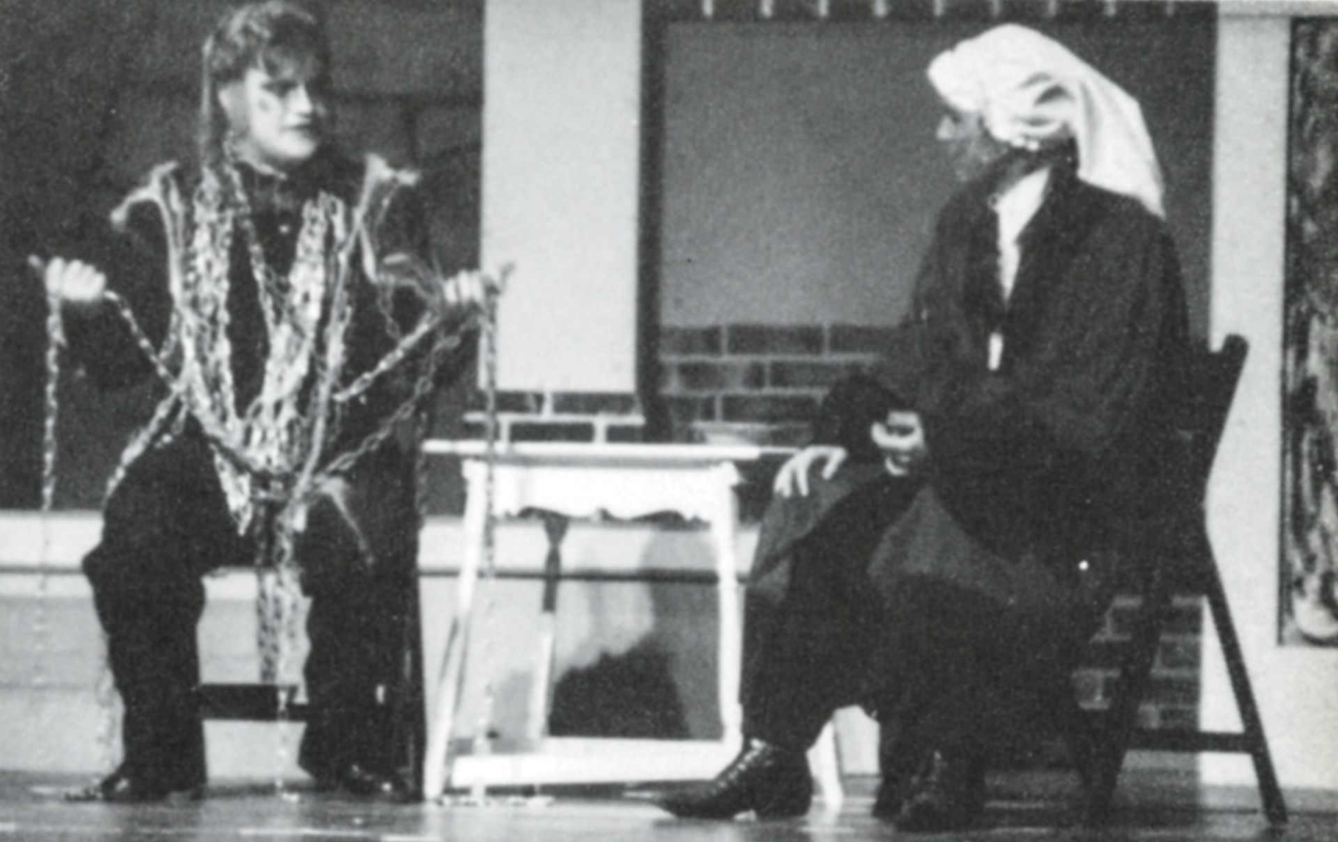 Male student in chains sitting on left, male student in stocking cap on right