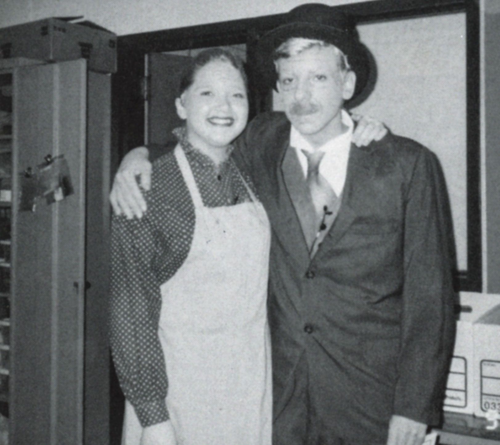 Male and female student with arms around each other, in vintage clothing