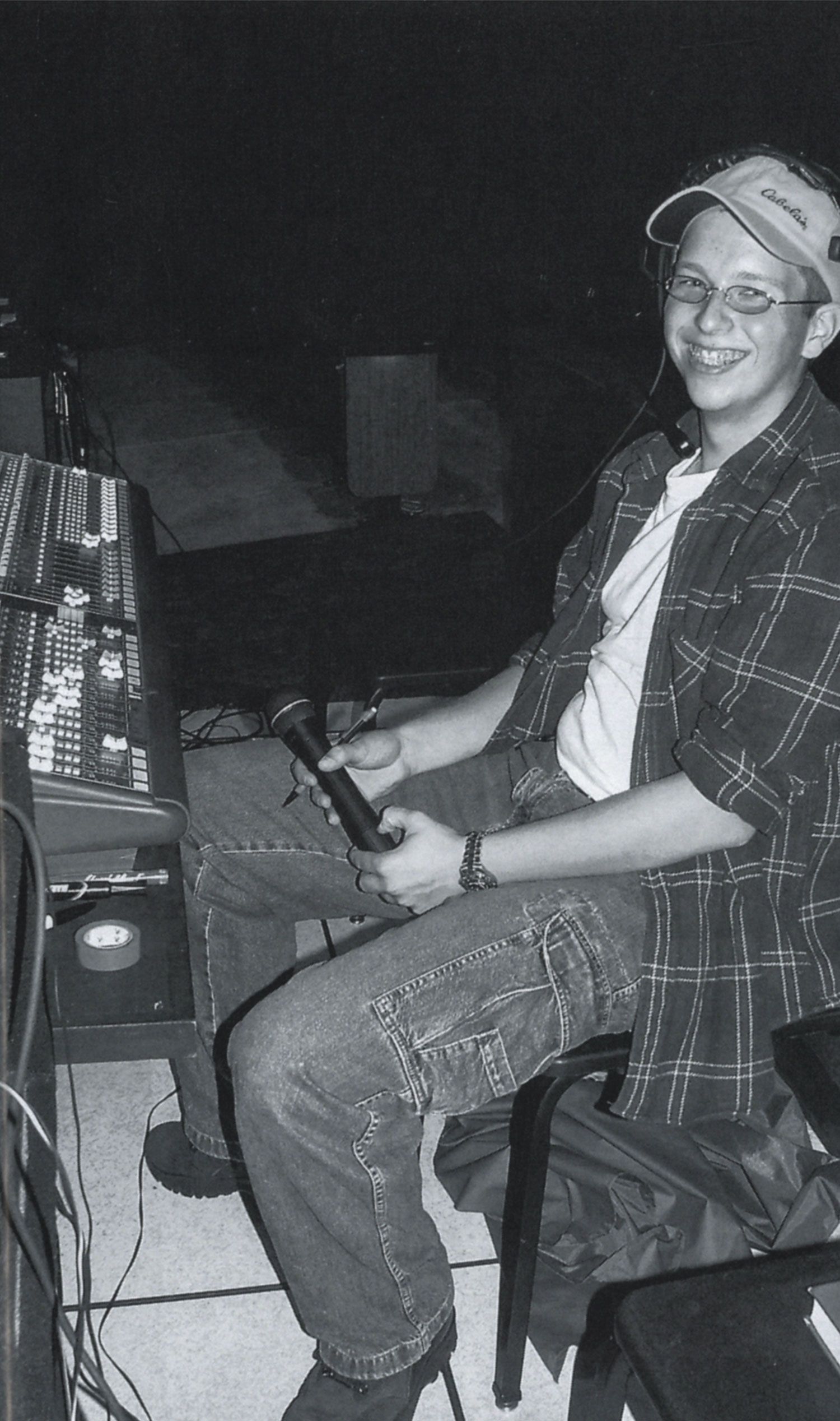 Tech student at a control board--he is smiling at the camera